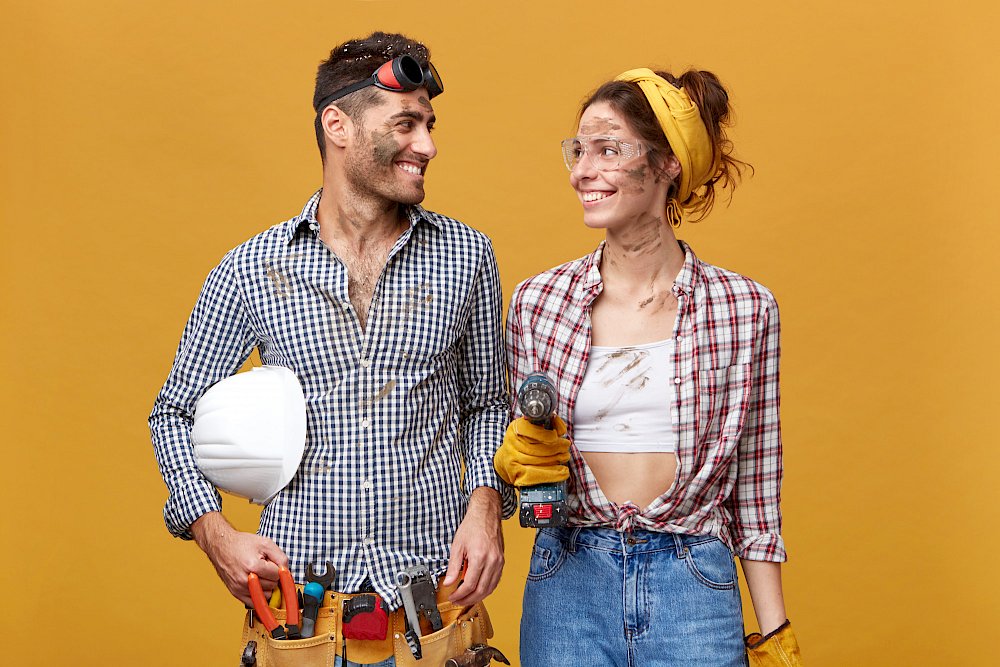 Žena s mužem v pracovním oblečení, s nářadím, ušpinění od rekonstruování domu